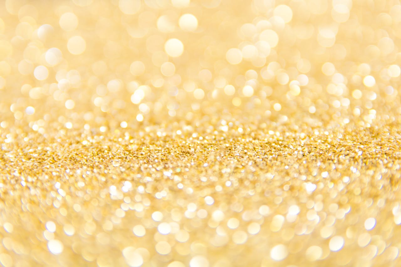 Abstract gold glitter background with a bokeh effect, ideal for festive designs.